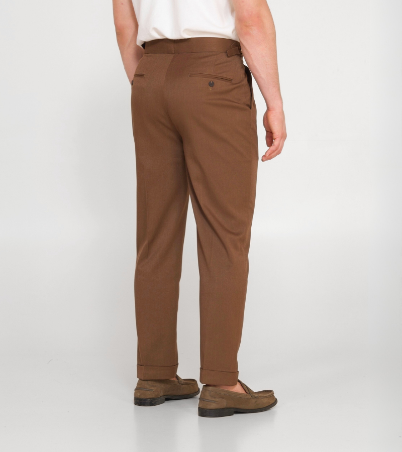 Brown pants worn by a person on a white background