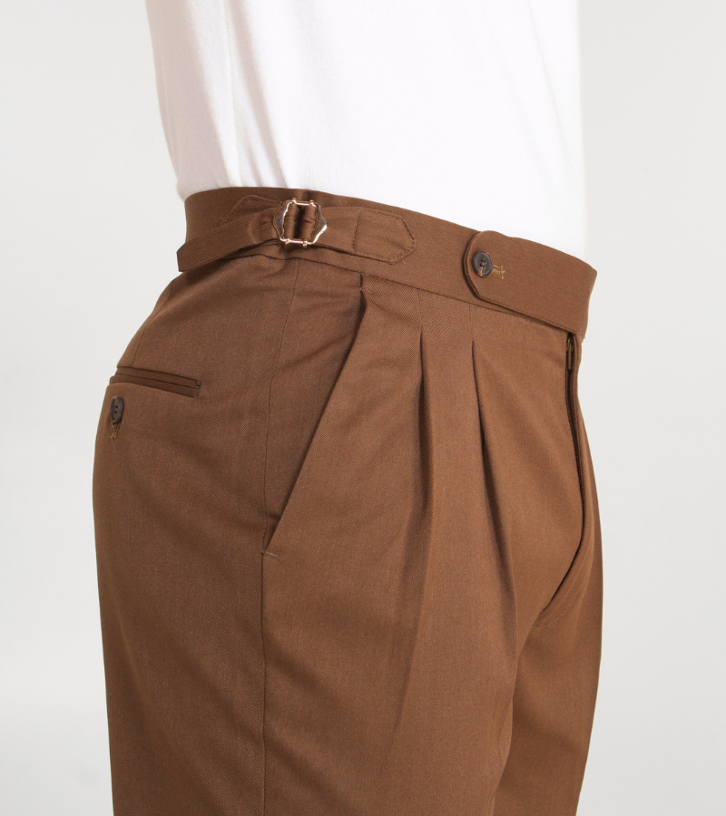 Brown pleated pants with a belt on a white background