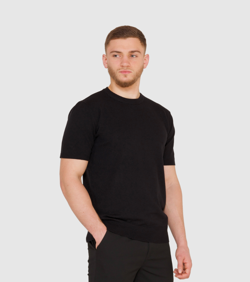 Man wearing a black t-shirt and pants on a white background