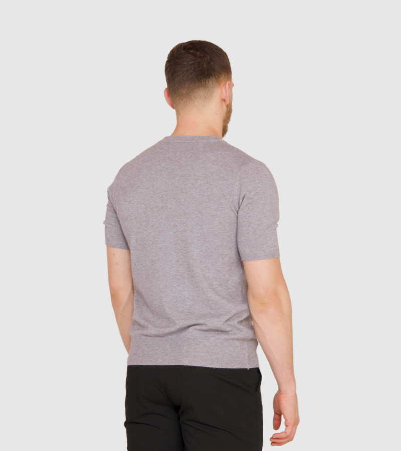 Man wearing a gray t-shirt on a plain background
