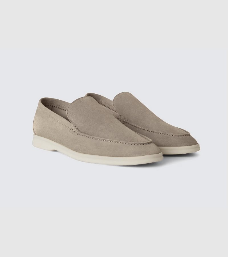 Pair of beige loafers on a light gray background